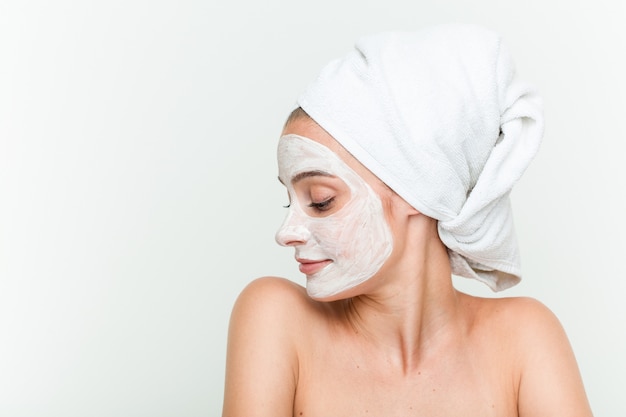 Young caucasian woman enjoying of a facial mask treatment