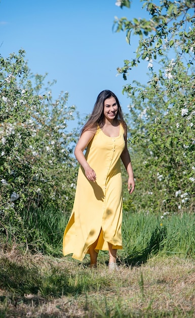 Young caucasian woman enjoying the flowering of an apple trees