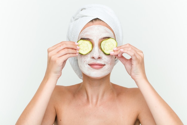 Young caucasian woman enjoying offacial mask treatment with cucumber