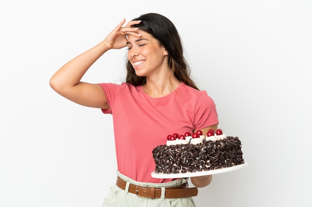 Young caucasian woman holding birthday cake isolated on white background smiling a lot