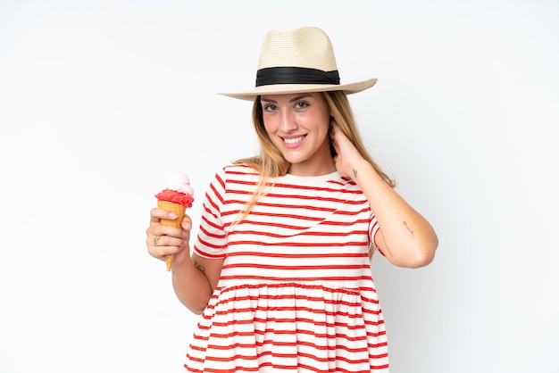 Young caucasian woman holding a cornet ice cream isolated on white background laughing