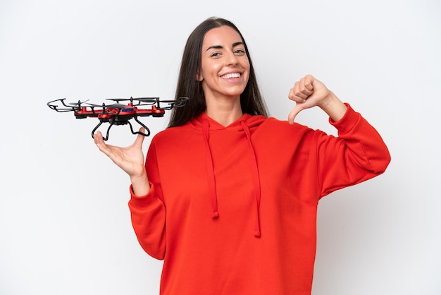 Young caucasian woman holding a drone isolated on white background proud and selfsatisfied