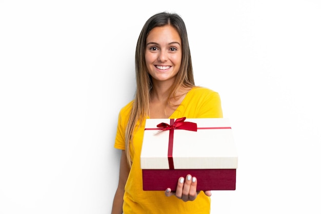 Young caucasian woman holding a gift isolated on white background with happy expression