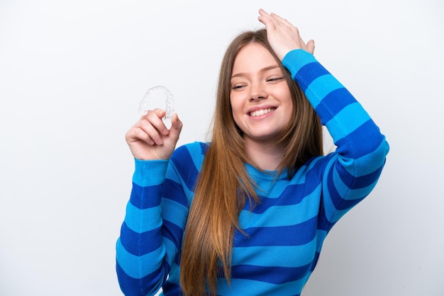 Young caucasian woman holding invisible braces isolated on white background has realized something and intending the solution