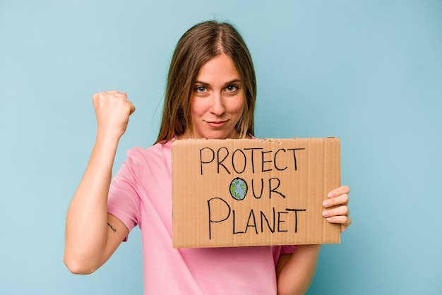 Young caucasian woman holding protect your planet placard isolated on blue background