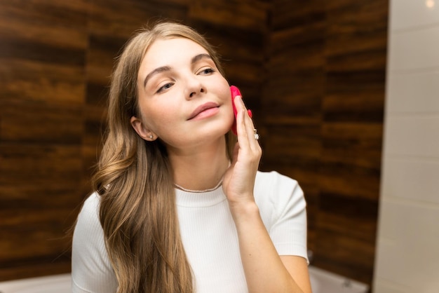 A young caucasian woman is doing a facial massage