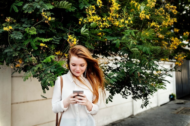 Young caucasian woman is using mobile phone