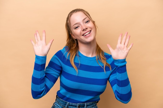 Young caucasian woman isolated on beige background counting ten with fingers