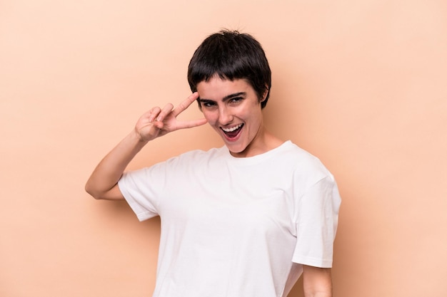 Young caucasian woman isolated on beige background dancing and having fun