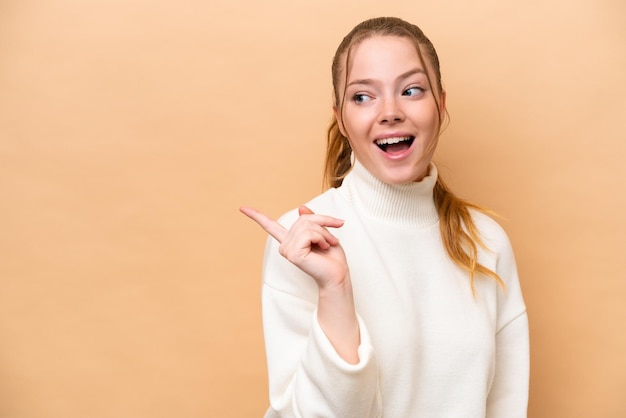 Young caucasian woman isolated on beige background intending to realizes the solution while lifting a finger up