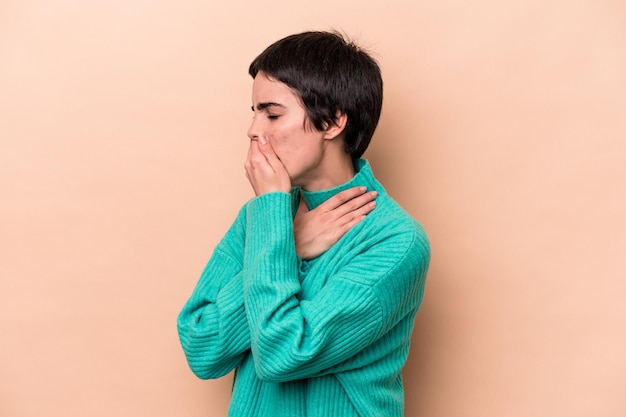 Photo young caucasian woman isolated on beige background suffers pain in throat due a virus or infection.