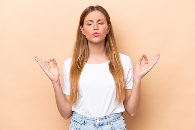 Young caucasian woman isolated on beige background in zen pose