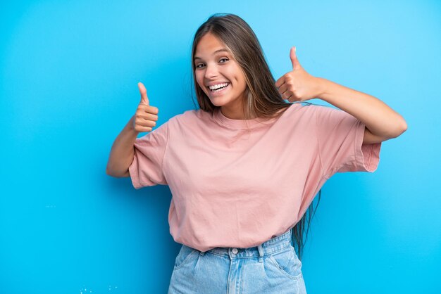 Young caucasian woman isolated on blue background giving a thumbs up gesture