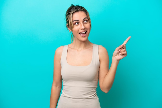 Young caucasian woman isolated on blue background intending to realizes the solution while lifting a finger up