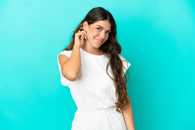 Young caucasian woman isolated on blue background laughing