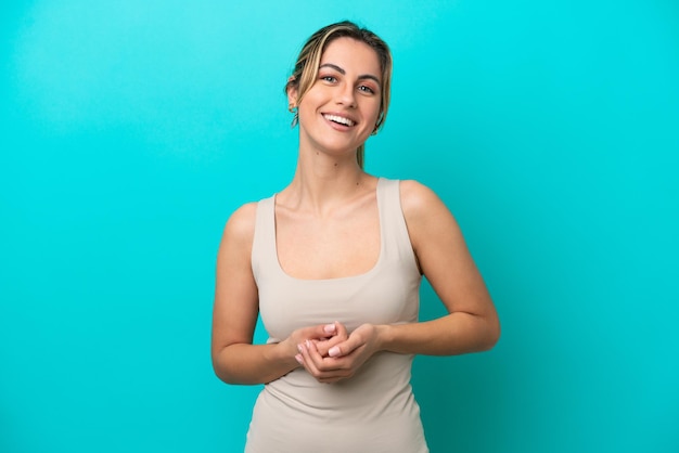 Young caucasian woman isolated on blue background laughing