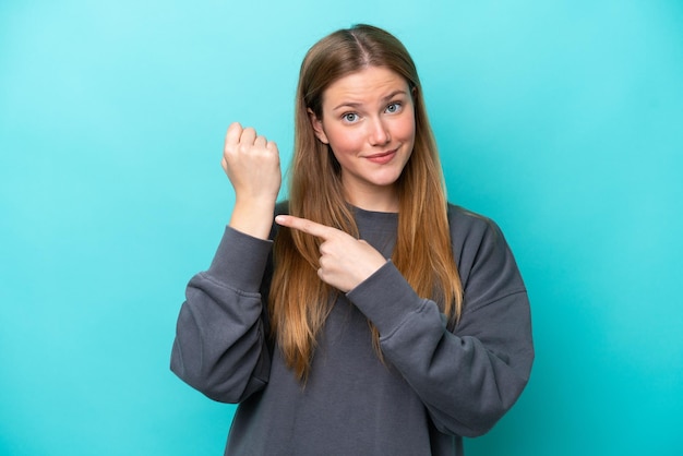 Young caucasian woman isolated on blue background making the gesture of being late