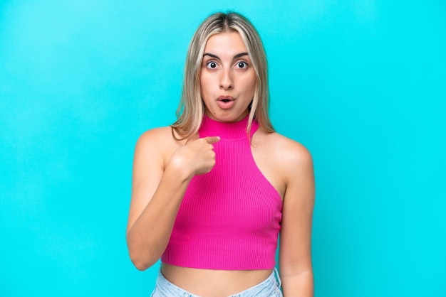 Young caucasian woman isolated on blue background pointing to oneself