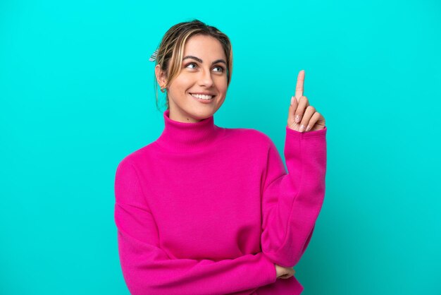 Young caucasian woman isolated on blue background pointing up a great idea