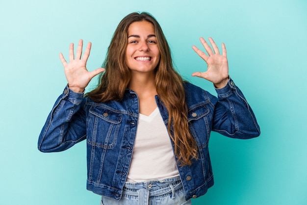 Young caucasian woman isolated on blue background  showing number ten with hands.