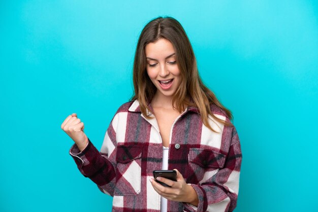 Young caucasian woman isolated on blue background surprised and sending a message