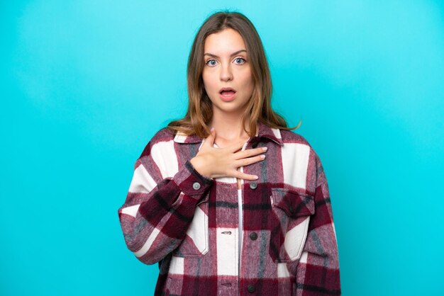 Young caucasian woman isolated on blue background surprised and shocked while looking right