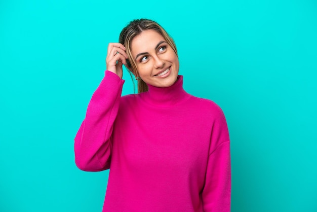 Young caucasian woman isolated on blue background thinking an idea