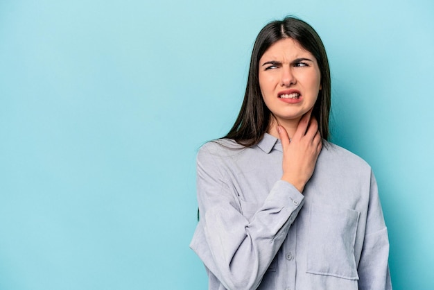 Young caucasian woman isolated on blue background touching back of head thinking and making a choice