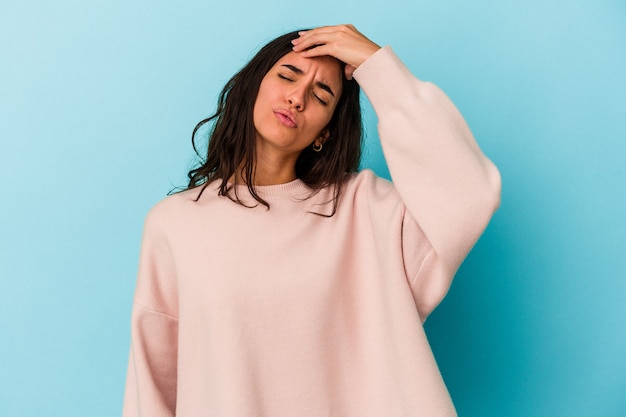 Young caucasian woman isolated on blue background touching temples and having headache.