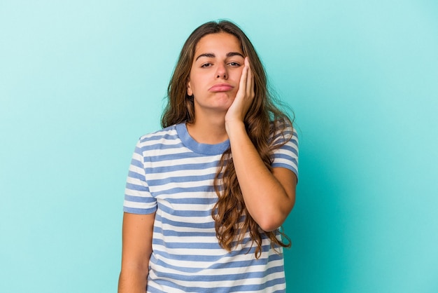 Young caucasian woman isolated on blue background  who feels sad and pensive, looking at copy space.