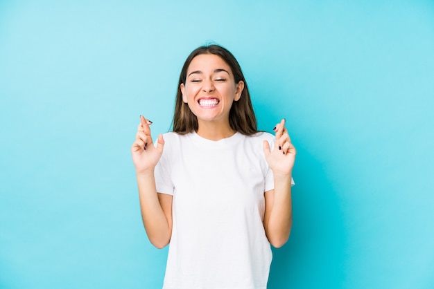 Young caucasian woman  isolated crossing fingers for having luck