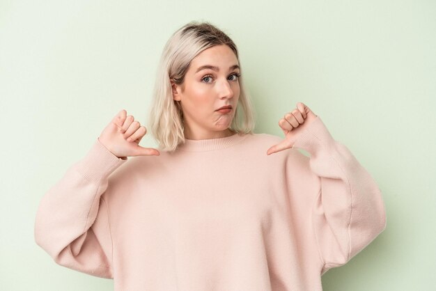 Photo young caucasian woman isolated on green background feels proud and self confident, example to follow.