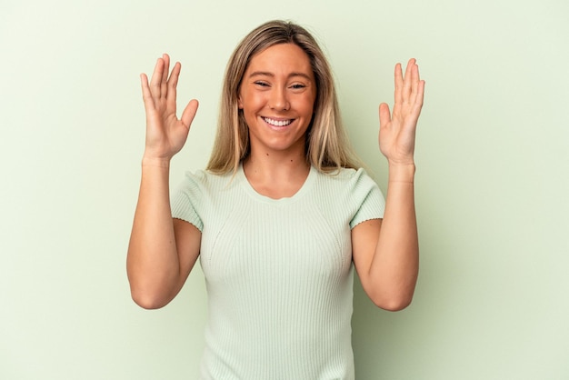 Young caucasian woman isolated on green background joyful laughing a lot. Happiness concept.