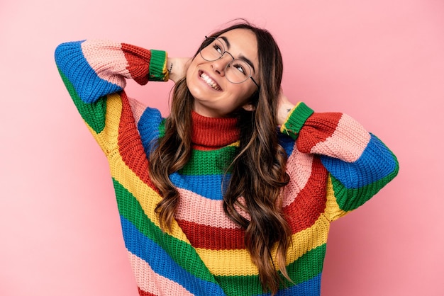 Young caucasian woman isolated on pink background feeling confident with hands behind the head