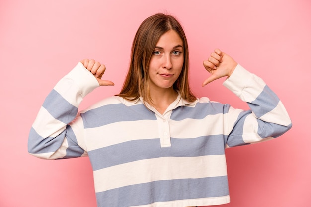 Photo young caucasian woman isolated on pink background feels proud and self confident example to follow