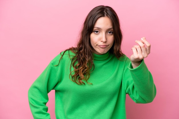 Young caucasian woman isolated on pink background making Italian gesture