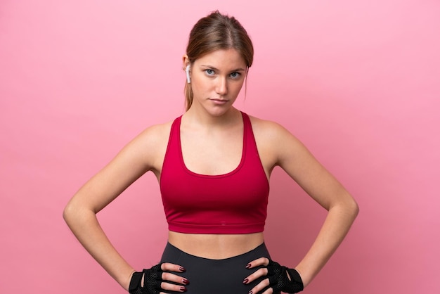 Young caucasian woman isolated on pink background posing with arms at hip