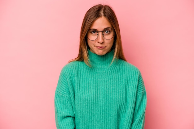 Young caucasian woman isolated on pink background sad serious face feeling miserable and displeased