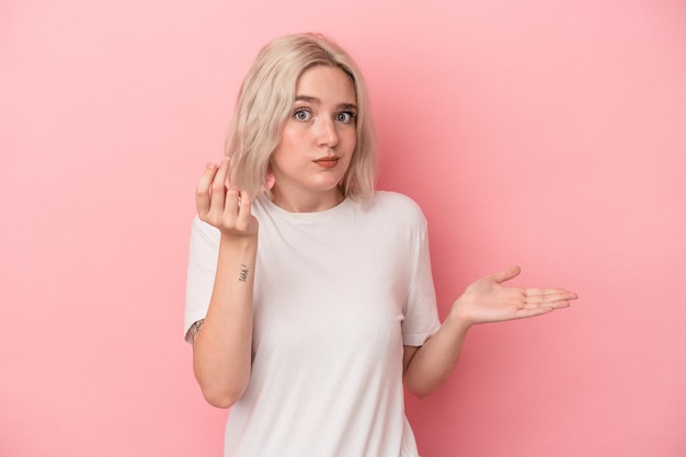 Photo young caucasian woman isolated on pink background showing that she has no money