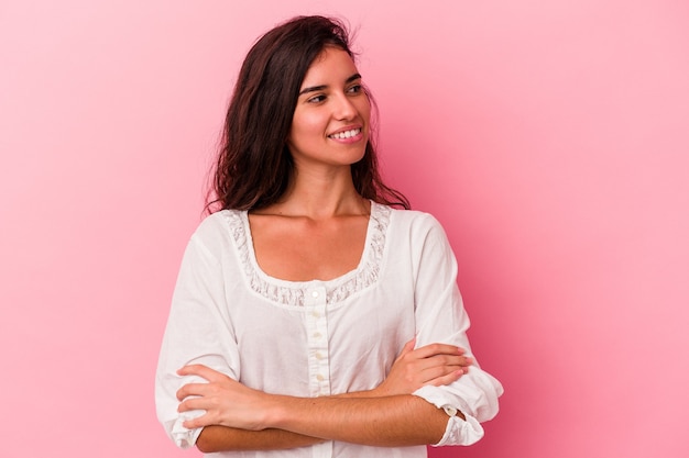 Young caucasian woman isolated on pink background smiling confident with crossed arms.