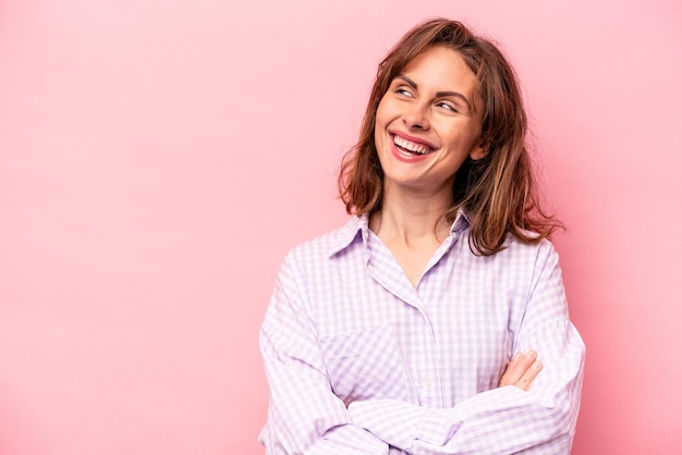 Young caucasian woman isolated on pink background smiling confident with crossed arms