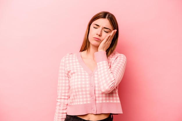 Young caucasian woman isolated on pink background who is bored fatigued and need a relax day