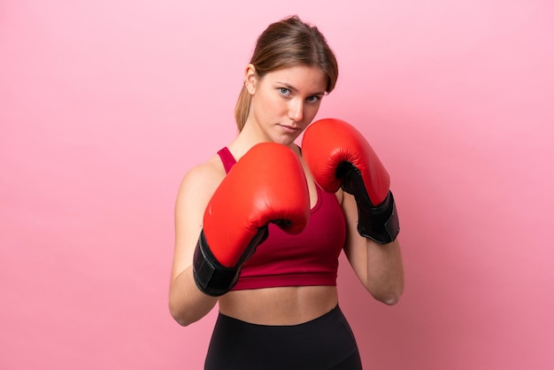 Young caucasian woman isolated on pink background with boxing gloves