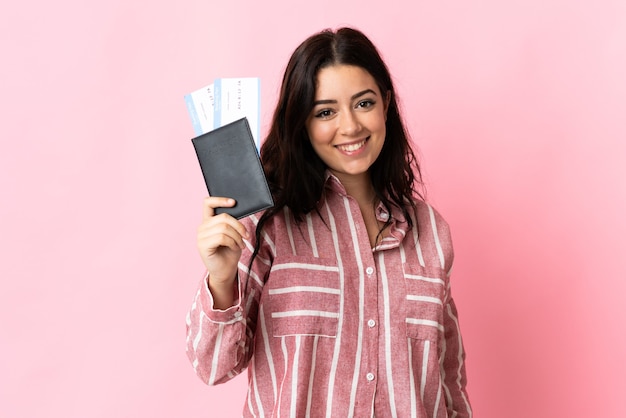 Young caucasian woman isolated on pink happy in vacation with passport and plane tickets