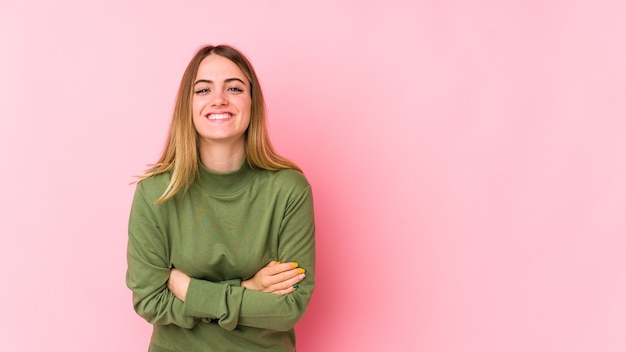 Photo young caucasian woman isolated on pink laughing and having fun.