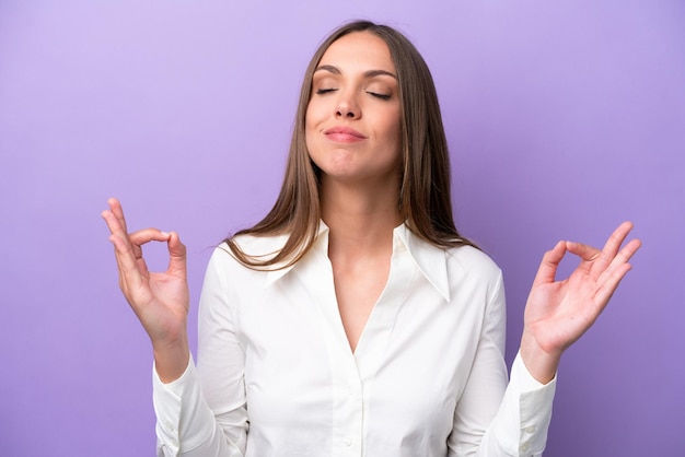 Young caucasian woman isolated on purple background in zen pose