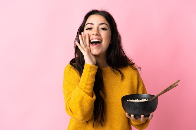 Young caucasian woman isolated shouting with mouth wide open while holding a bowl