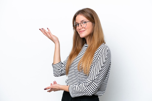 Young caucasian woman isolated on white background extending hands to the side for inviting to come