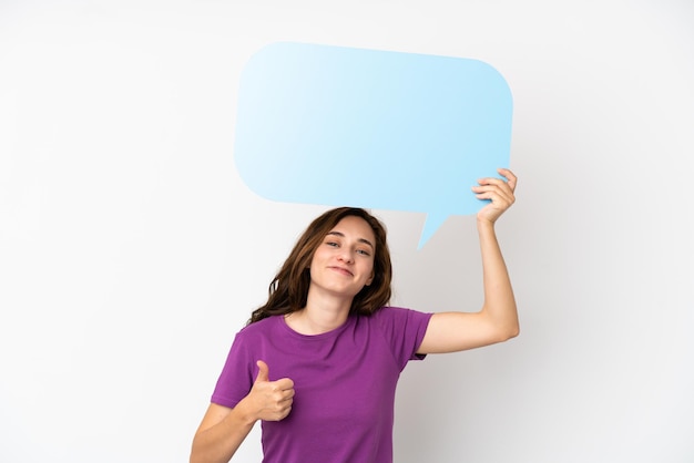 Young caucasian woman isolated on white background holding an empty speech bubble with thumb up