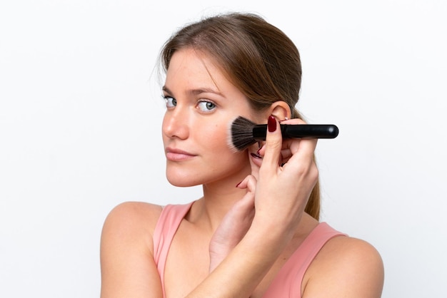 Young caucasian woman isolated on white background holding makeup brush